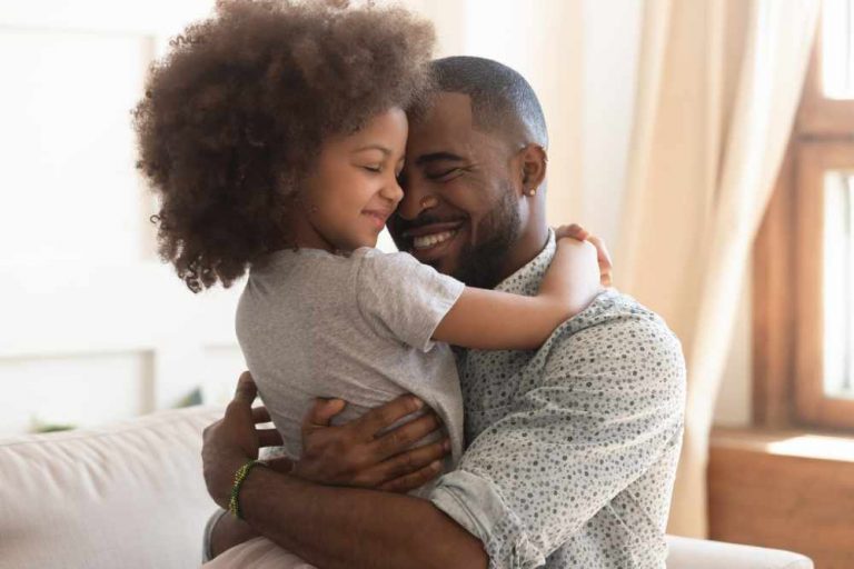 Sweet moments of fatherhood concept, happy father hold embrace cute little child daughter, smiling black family daddy and small kid hugging cuddling enjoying time together at home