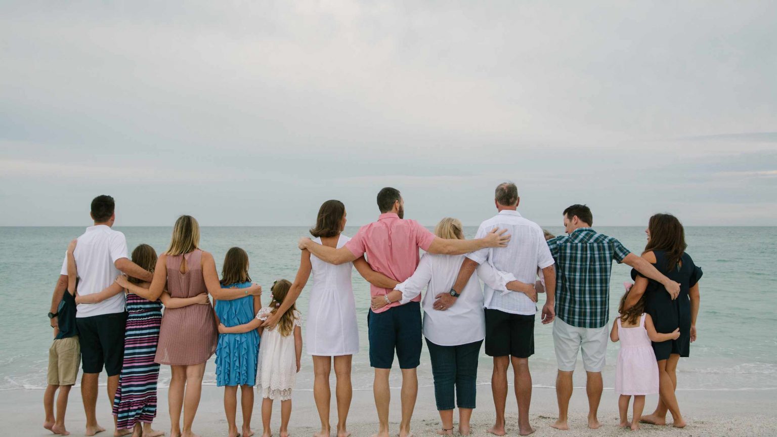 extended family standing on a beach