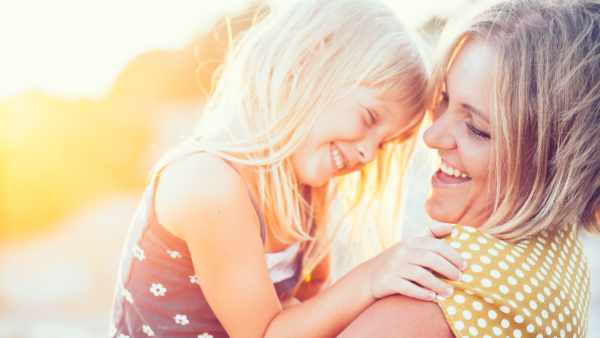 Mom playing with her child outdoors in sunlight