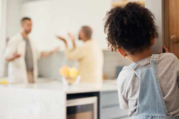 Lgbt, divorce and girl child watching gay parents argue in kitchen with stress, worry or fear in their home. Family, crisis and homosexual men dispute foster kid custody, affair or conflict in house